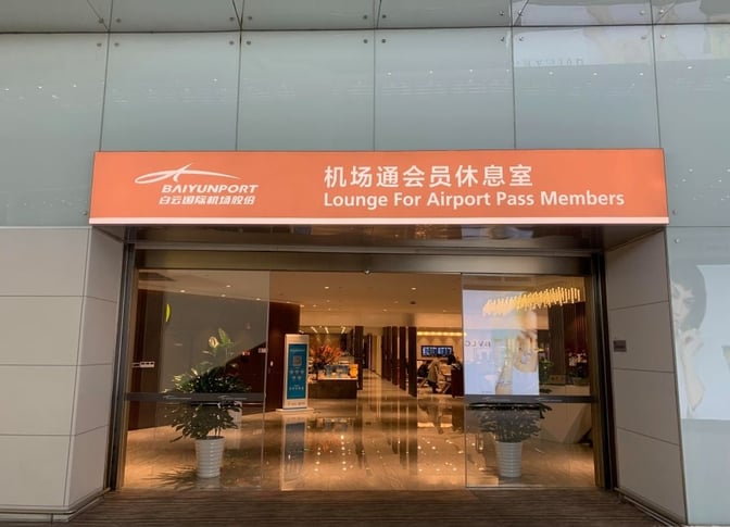The entrance to the Lounge for Airport Pass Members at Guangzhou Baiyun International Airport features sliding glass doors and visible interior plants.