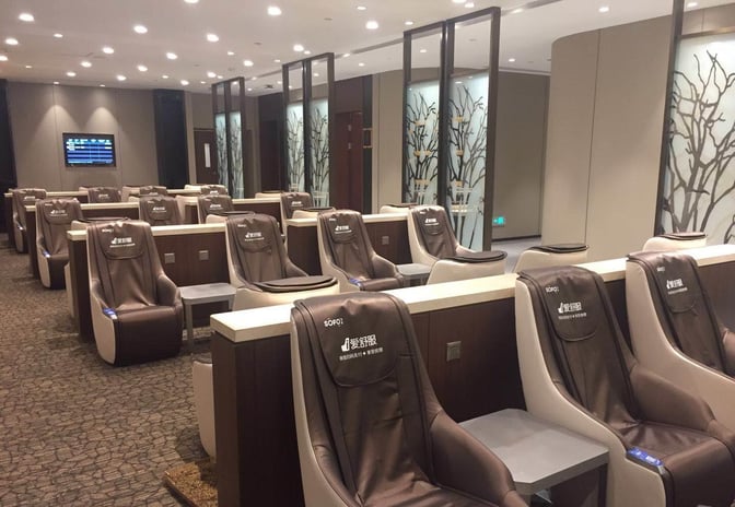 The seating area in the airport lounge at Guangzhou Baiyun International Airport features individual massage chairs with privacy partitions.