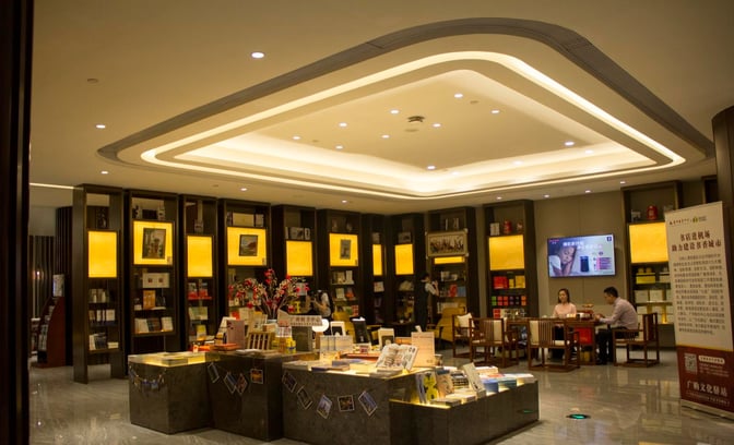 The lounge at Guangzhou Baiyun International Airport features a reading area with bookshelves, seating, and informational displays for passengers.