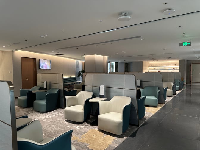 The L34 Lounge at Guangzhou Baiyun International Airport features semi-private seating areas with individual chairs and tables for passenger comfort.