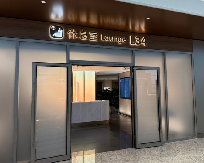 The entrance to Lounge L34 at Guangzhou Baiyun International Airport features glass doors and a visible reception area inside.