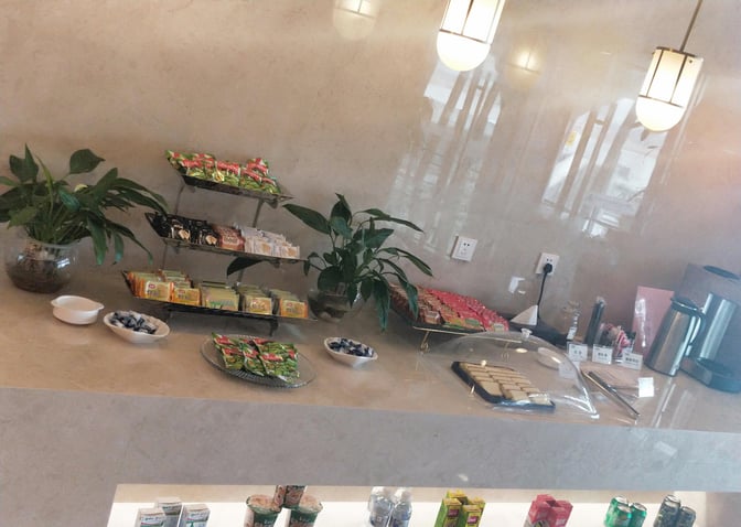 The snack area in Guilin Liangjiang International Airport's lounge offers packaged snacks, cookies, and beverages for travelers.