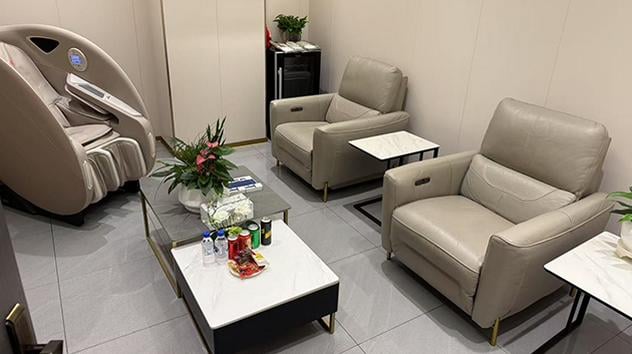 The lounge at Guiyang Longdongbao International Airport features comfortable seating with armchairs, a massage chair, and a table with refreshments.