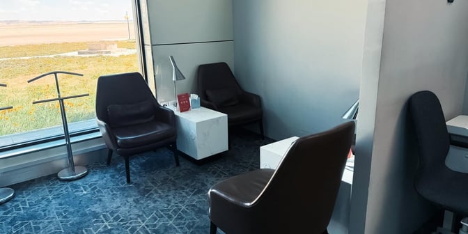 The seating area in Hayyak Lounge at Gurayat Domestic Airport features armchairs, small tables, and a view of the airfield.