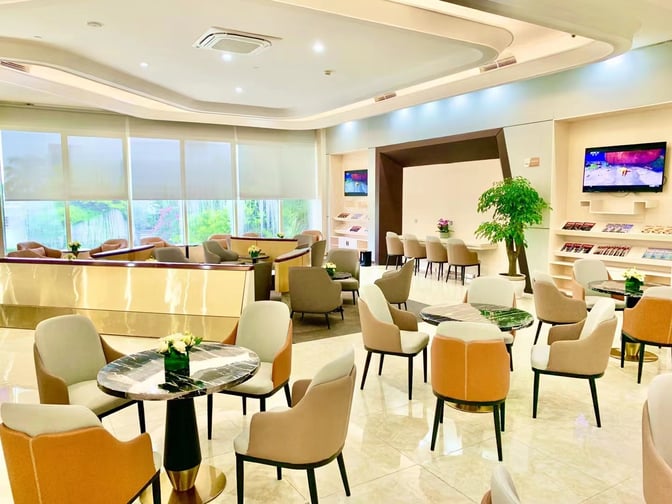 The Easy Travel Lounge 2 at Haikou Meilan International Airport features seating areas with tables, televisions, and reading materials for travelers.