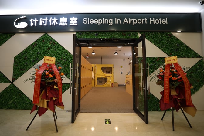 The entrance to the Sleeping In Airport Hotel at Haikou Meilan International Airport features capsule sleeping pods and locker storage.