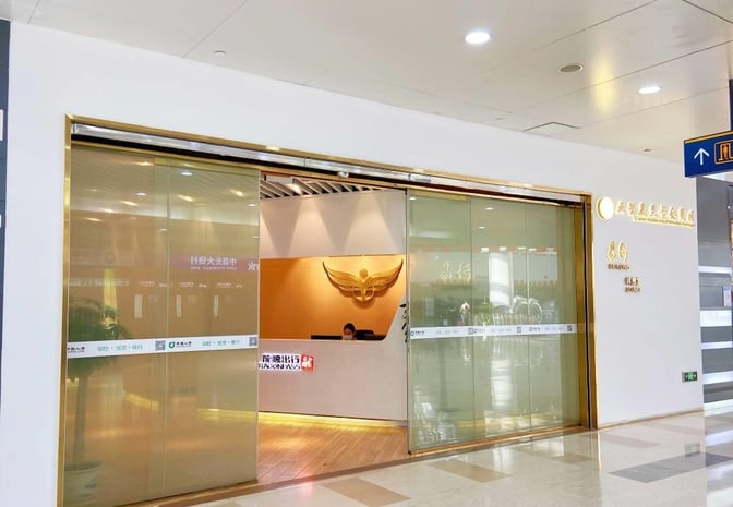 The entrance to Trvok Lounge at Haikou Meilan International Airport features a reception desk and sliding glass doors.