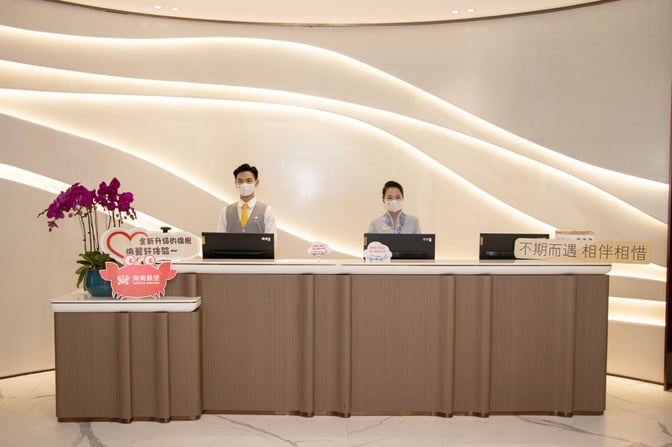 The reception desk at Hainan Airlines Lounge in Haikou Meilan International Airport features staff ready to assist travelers.