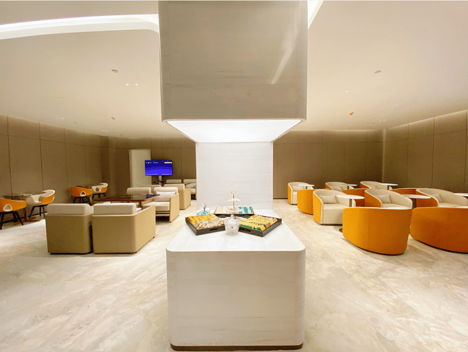 The seating area in Business Lounge 4 at Haikou Meilan International Airport features comfortable chairs and a central snack station.