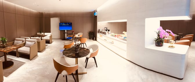 The Business Lounge 4 at Haikou Meilan International Airport features a seating area with tables and a self-serve snack station.