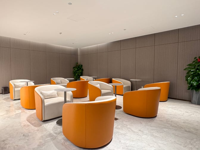 The seating area in Business Lounge 4 at Haikou Meilan International Airport features individual chairs with small tables for travelers.