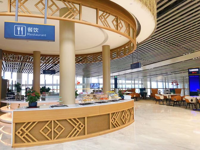 The restaurant area in the International First Class Lounge at Haikou Meilan International Airport features self-serve food stations and seating.