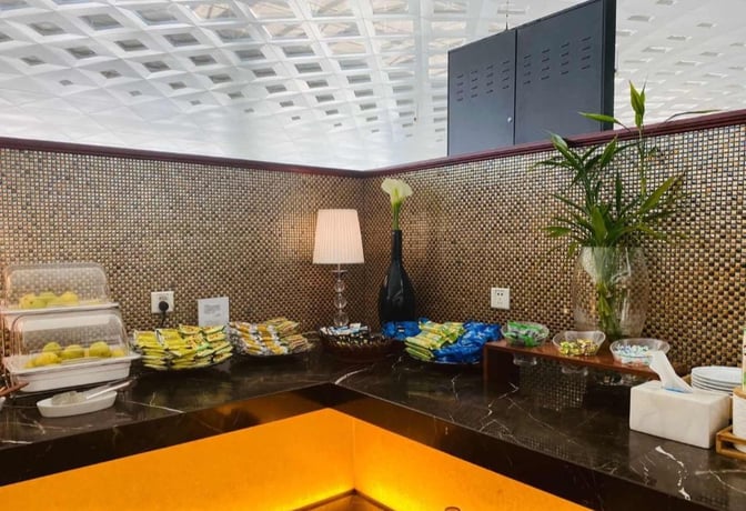 Self-serve snack station in Hangzhou Xiaoshan International Airport's First Class Lounge offers packaged snacks and fresh fruit options.