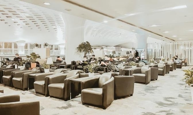 The seating area in the First Class Lounge at Hangzhou Xiaoshan International Airport features numerous armchairs and tables for passenger comfort.