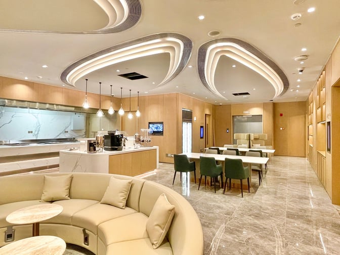 The VIP Lounge 16 at Hangzhou Xiaoshan International Airport features a seating area with curved sofas and a self-serve beverage station.