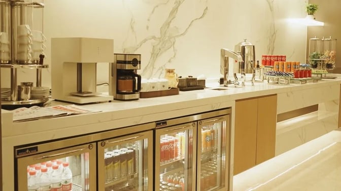 The VIP lounge at Hangzhou Xiaoshan International Airport features a self-serve beverage station with coffee machines, drink dispensers, and refrigerated drinks.