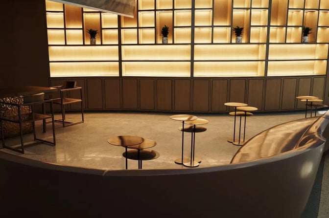 The VIP Lounge V25 at Hangzhou Xiaoshan International Airport features a seating area with small tables and decorative shelving.