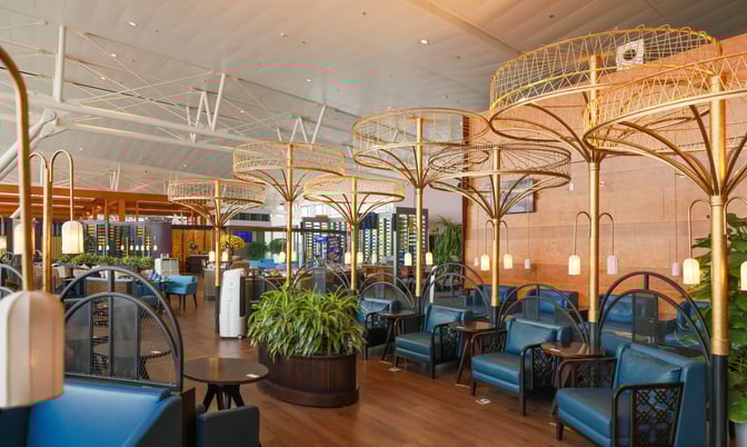 The SH Premium Lounge at Noi Bai International Airport features comfortable seating areas with tables and decorative overhead structures.