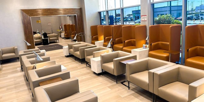 The seating area in Hayyak Lounge at Ta’if International Airport features individual chairs with side tables and reading lamps.