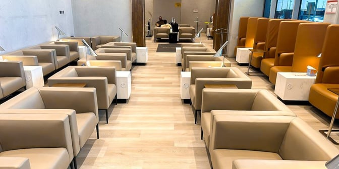 The seating area in Hayyak Lounge at Ta’if International Airport features individual armchairs with side tables and power outlets.