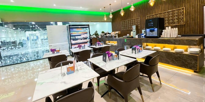 The Hayyak Lounge at Ta’if International Airport features a dining area with tables, chairs, and a self-serve beverage and snack station.