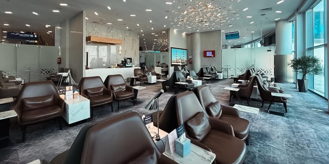 The Hayyak Lounge at Arar Domestic Airport features comfortable seating with individual tables, a service counter, and a view of the tarmac.