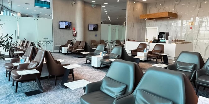 The seating area in Hayyak Lounge at Arar Domestic Airport features comfortable chairs with individual tables and a refreshment counter.