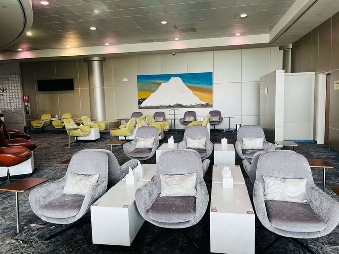 The seating area in Hayyak Lounge at Bisha Domestic Airport features comfortable chairs with side tables, arranged for relaxation.
