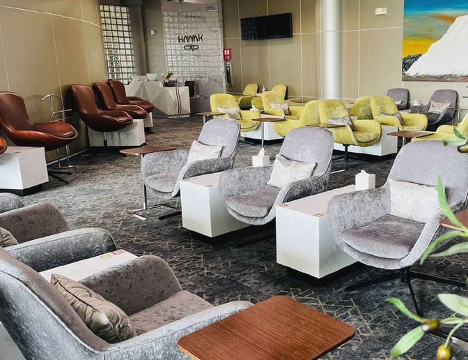 The Hayyak Lounge at Bisha Domestic Airport features a seating area with cushioned chairs and small tables for passenger comfort.