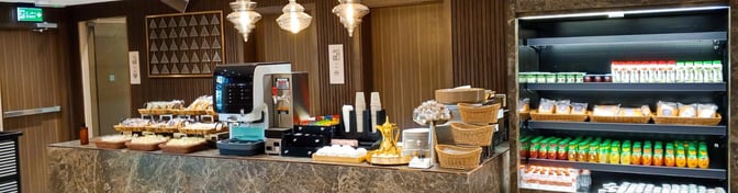 The Hayyak Lounge at Prince Naif bin Abdulaziz International Airport features a self-serve food station with snacks, beverages, and a coffee machine.