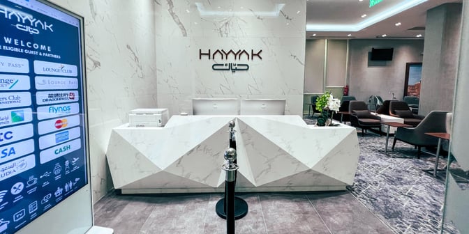 The Hayyak Lounge reception at Hail International Airport features a geometric counter and seating area for guests.