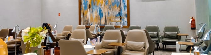 The seating area in Hayyak Lounge at Prince Naif bin Abdulaziz International Airport features comfortable chairs with side tables and decorative elements.