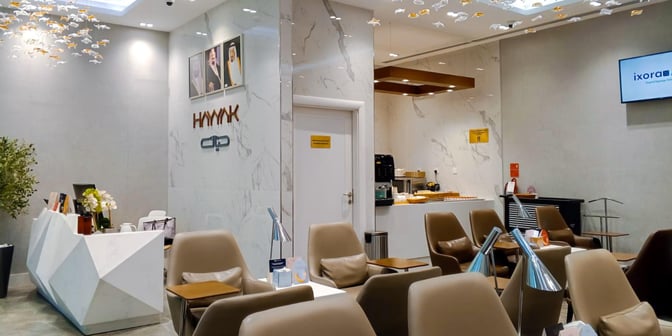 Seating area in Hayyak Lounge at Prince Naif bin Abdulaziz International Airport features comfortable chairs and a small refreshment station.