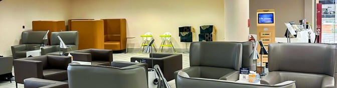 The Hayyak Lounge at Najran Regional Airport features a seating area with armchairs, high-backed booths, and a self-service kiosk.