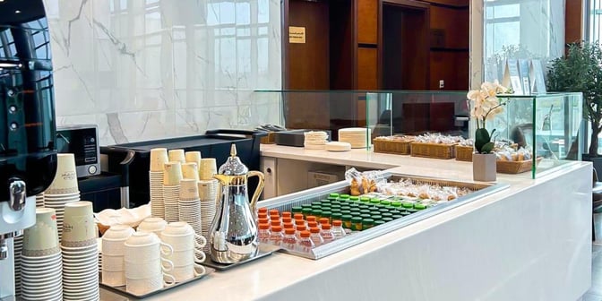 The Hayyak Lounge at Prince Sultan bin Abdul Aziz Airport features a self-serve refreshment area with beverages, snacks, and disposable cups.