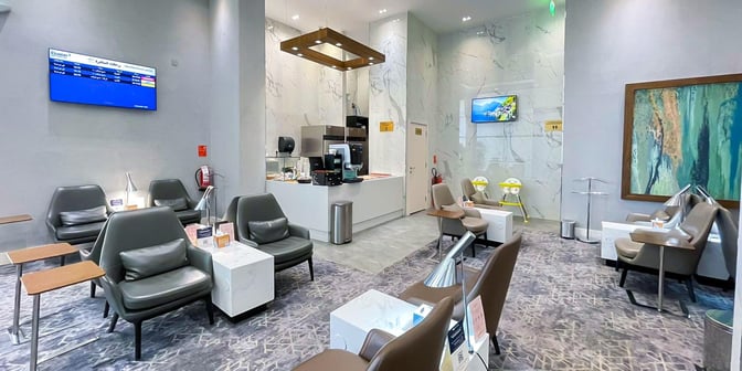 The Hayyak Lounge at Ta’if International Airport features seating areas with armchairs, a refreshment counter, and flight information displays.