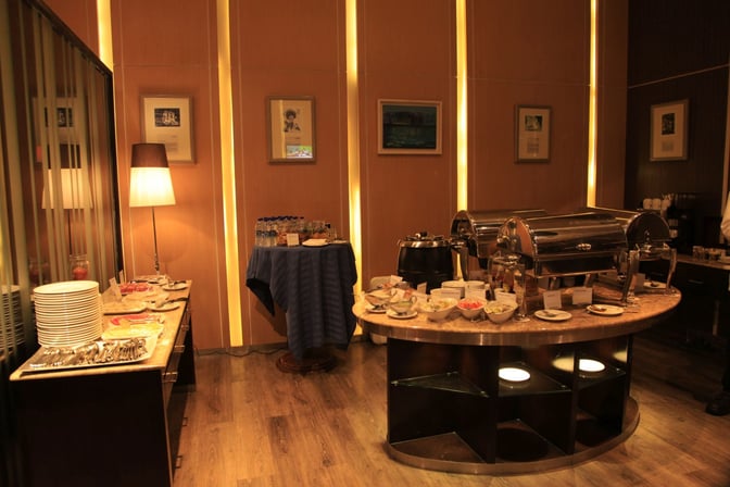 The MTB Air Lounge at Hazrat Shahjalal International Airport features a buffet area with chafing dishes, plates, and a selection of beverages.
