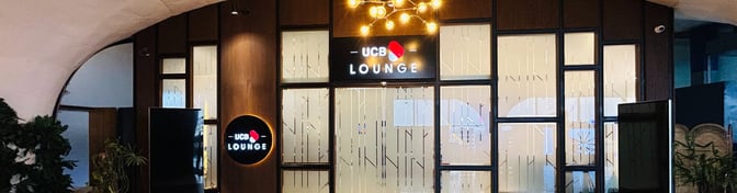 The entrance to the UCB Lounge at Hazrat Shahjalal International Airport features a prominent sign and glass-paneled doors.