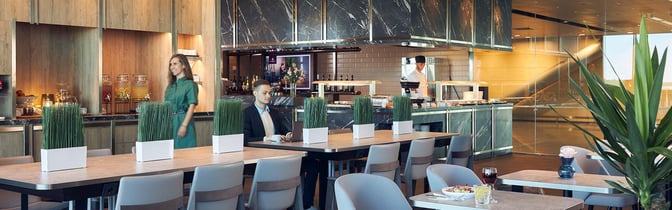 The Plaza Premium Lounge at Helsinki-Vantaa Airport features a dining area with self-serve food stations and seating for guests.