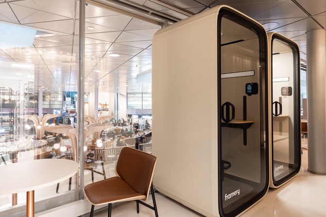 Private phone booths in the OP Lounge at Helsinki-Vantaa Airport offer a quiet space for calls, adjacent to seating and tables.