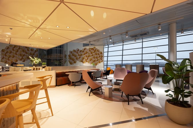 The OP Lounge at Helsinki-Vantaa Airport features a seating area with various chairs and tables, offering views of the airport.