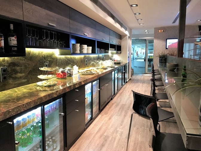 The Filoxenia Lounge at Heraklion Airport features a self-serve snack and beverage counter with adjacent seating for travelers.