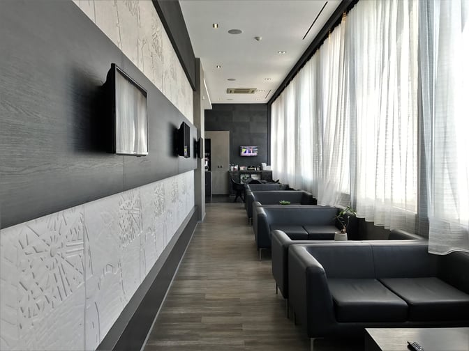 The Filoxenia Lounge at Heraklion International Airport features a seating area with sofas, wall-mounted televisions, and large windows.