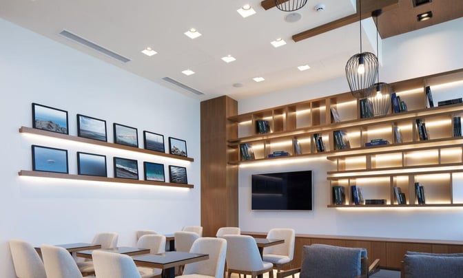 The Goldair Handling Lounge at Heraklion International Airport features a seating area with tables, chairs, and wall-mounted photographs.