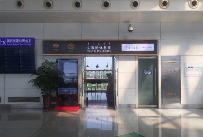 The entrance to the First Class Lounge at Hohhot Baita International Airport features clear signage and glass doors.