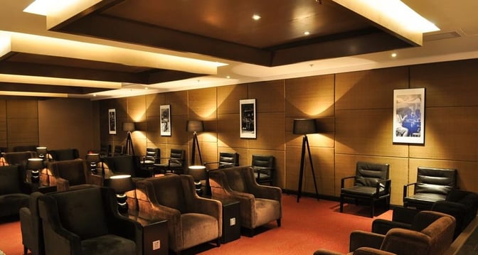 The seating area at Plaza Premium First lounge near Gate 1 features comfortable armchairs and side tables for relaxation.