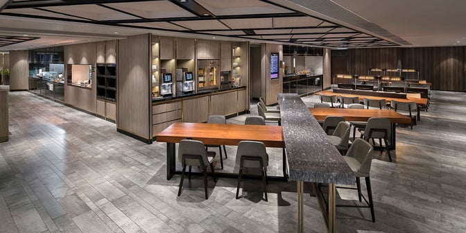 The Plaza Premium Lounge near Gate 1 at Hong Kong International Airport features a spacious seating area with tables and chairs.