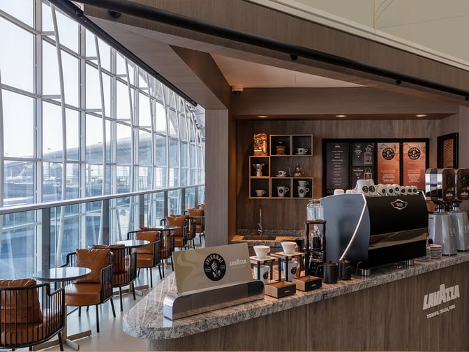 The coffee bar in Plaza Premium Lounge near Gate 60 at Hong Kong International Airport offers seating with airport views.