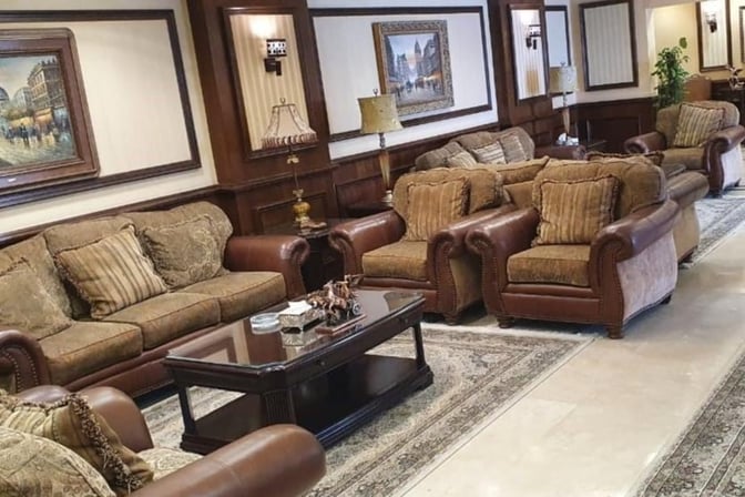 The seating area in the Pearl Lounge at Hurghada International Airport features comfortable armchairs and sofas with decorative lamps and artwork.