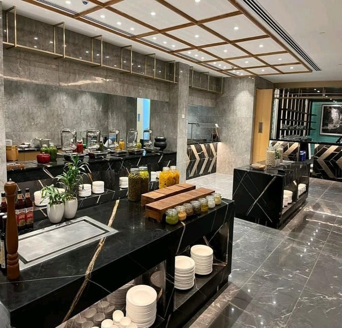 The Encalm Lounge at Indira Gandhi International Airport features a self-serve buffet area with various condiments and dining essentials.